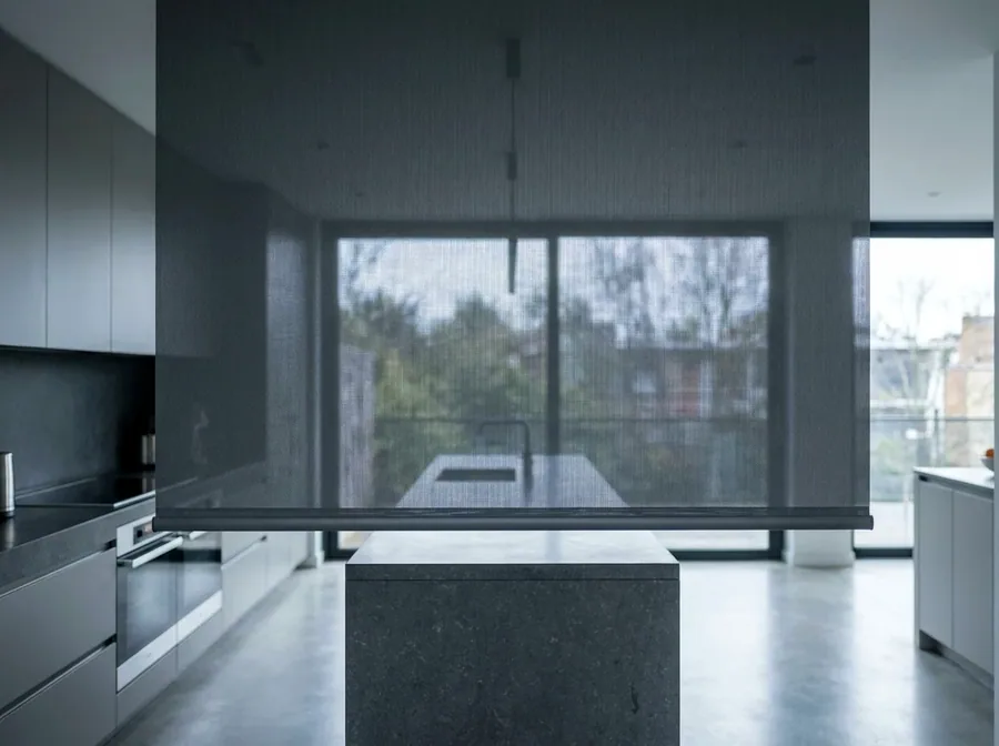Sunscreen roller blind in an open-plan kitchen — see-through weave cutting glare while keeping the view